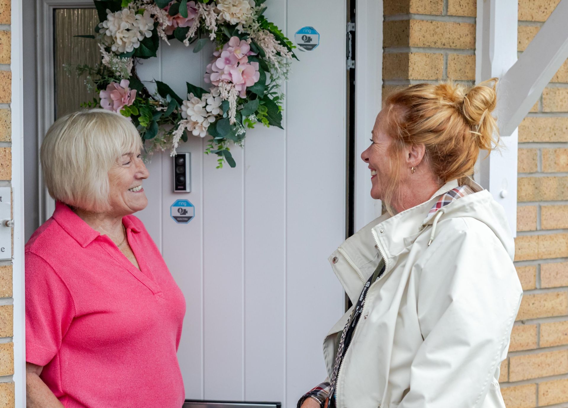 Colleagues standing outside home with resident