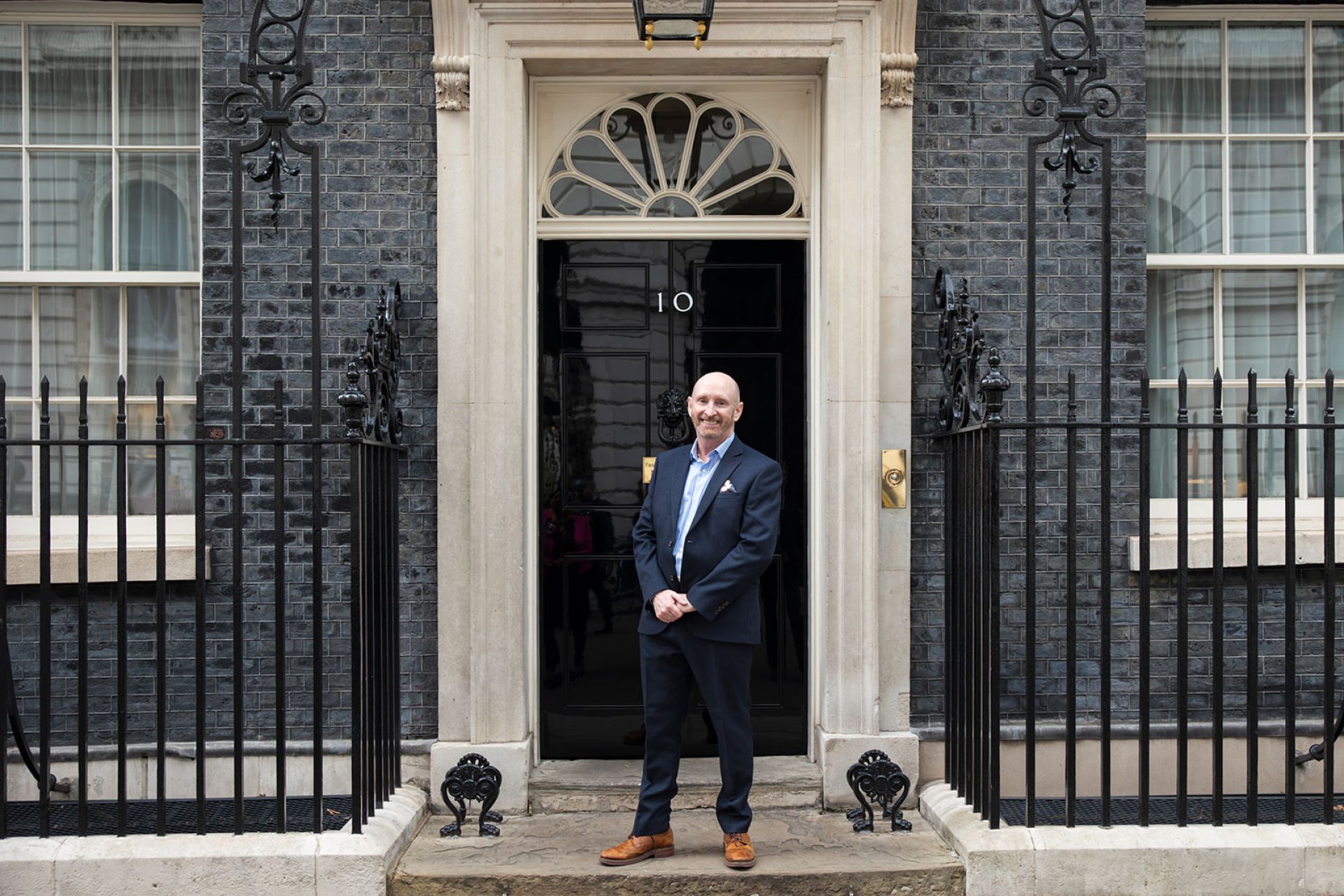 A person standing outside a 10 Downing Street