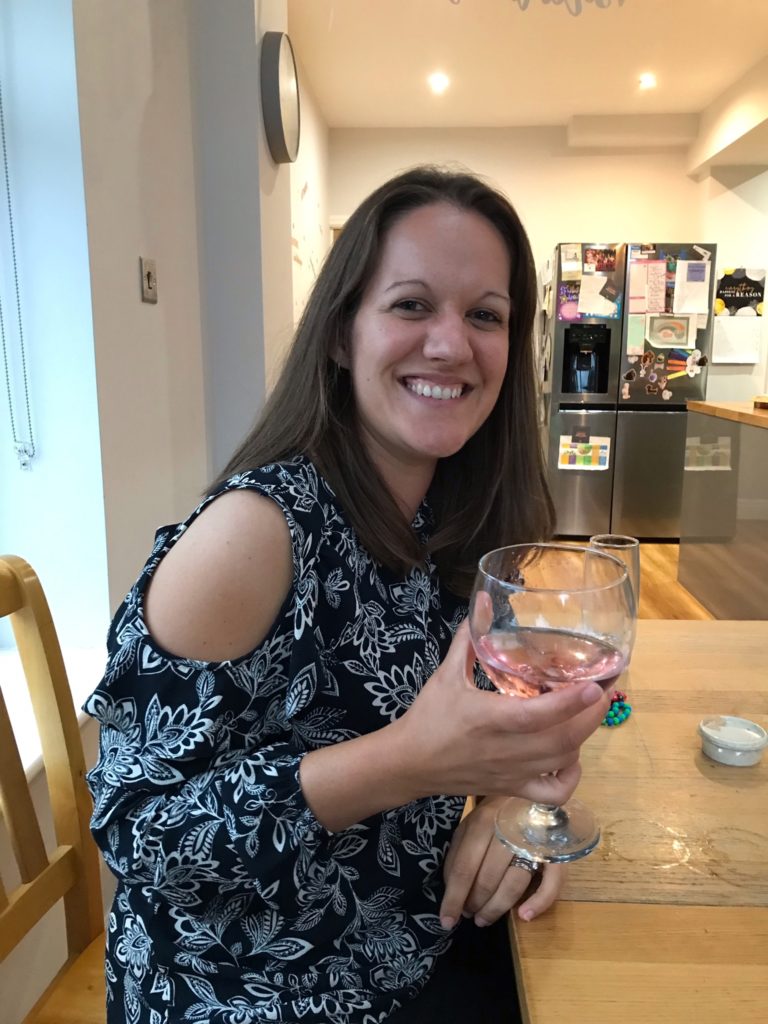 Ruth Richardson smiling with a glass of wine