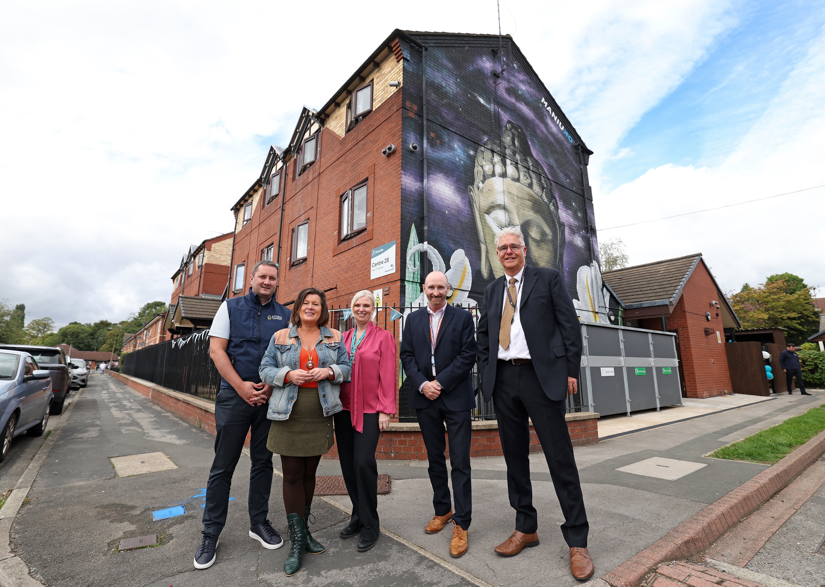 A group of people stand together outside of a building