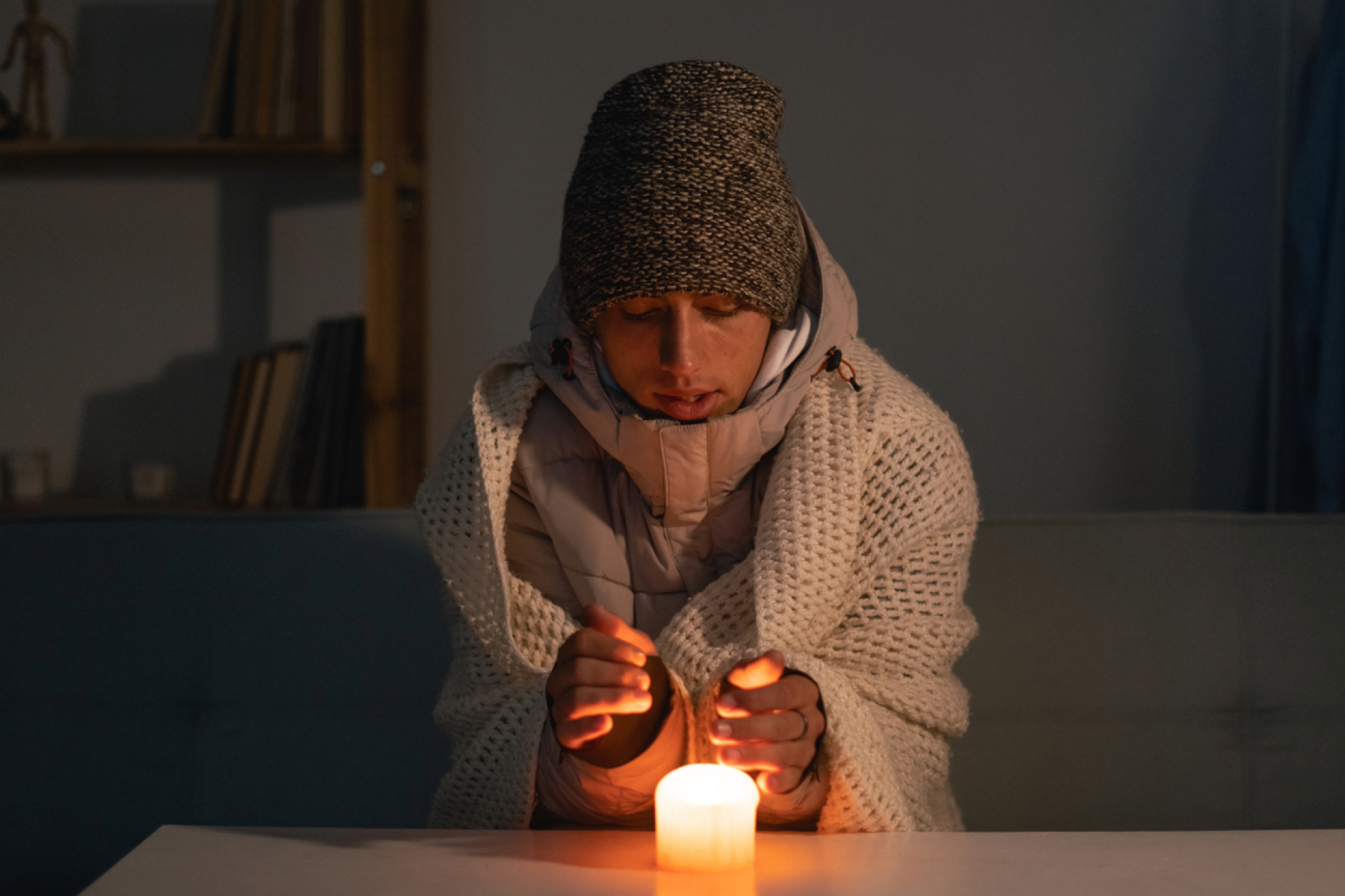 man sitting in dark with candle