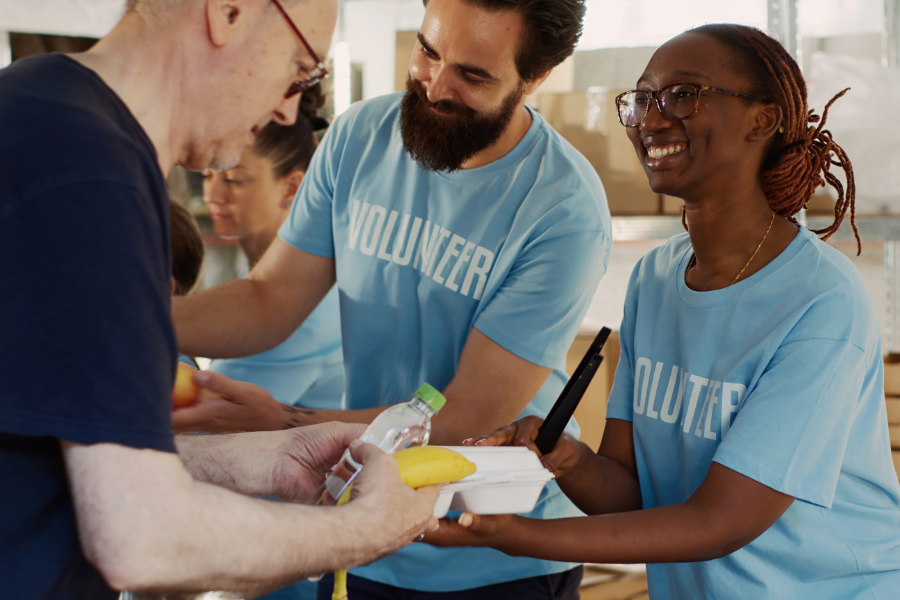 person being given food and drink from volunteers