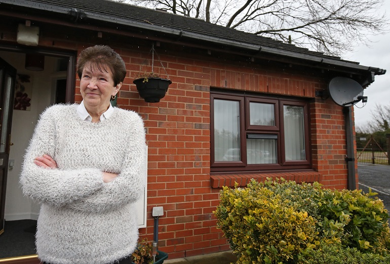 Lady outside Longshoot Close, Riverside's Retirement Living bungalows in Wigan