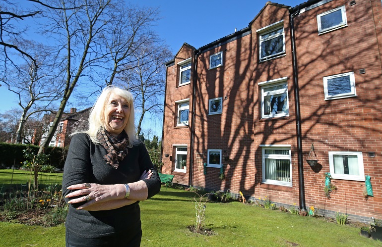 Lady outside McLaren Court, Riverside's Retirement apartments in Chorlton, Manchester
