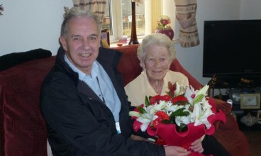 Neighbourhood Services Manager Jeff Allen presents Mary Jepson with flowers to mark her 90th birthday
