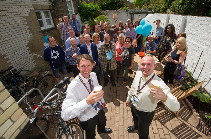 Riverside staff and residents past and presents raise a glass with guests to celebrate the refurbishment of Willow Walk homeless housing support in Cambridge.