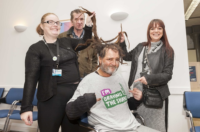 Graham Taylor, Riverside customer at Newbury House in Manchester, gets his dreadlocks cut off by barber Raimi Shoneye, watched by Riverside support worker Wendy Foran and Riverside team Kerry Kelly, (left) and Ross Jenkins.