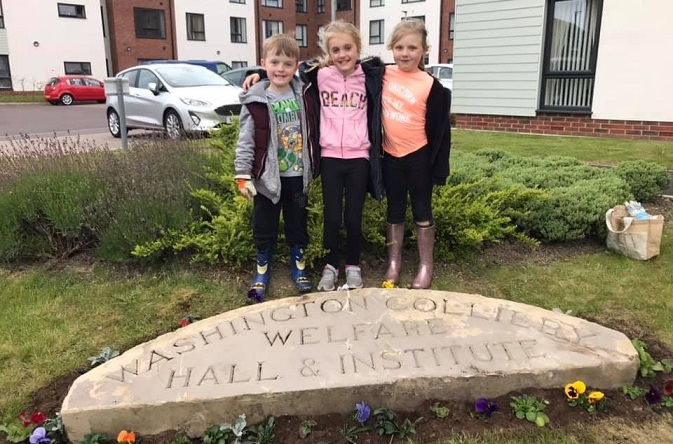 Here's the Little Onion Club planting flowers around the arch.