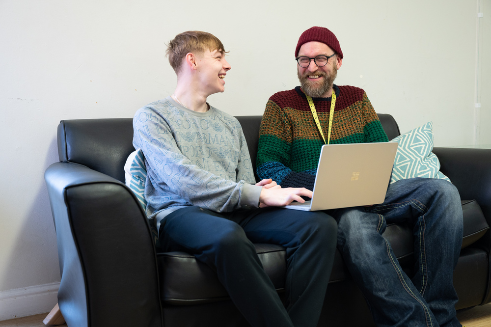 Customer and staff member meeting and looking at laptop at Centre 28 in Hull.