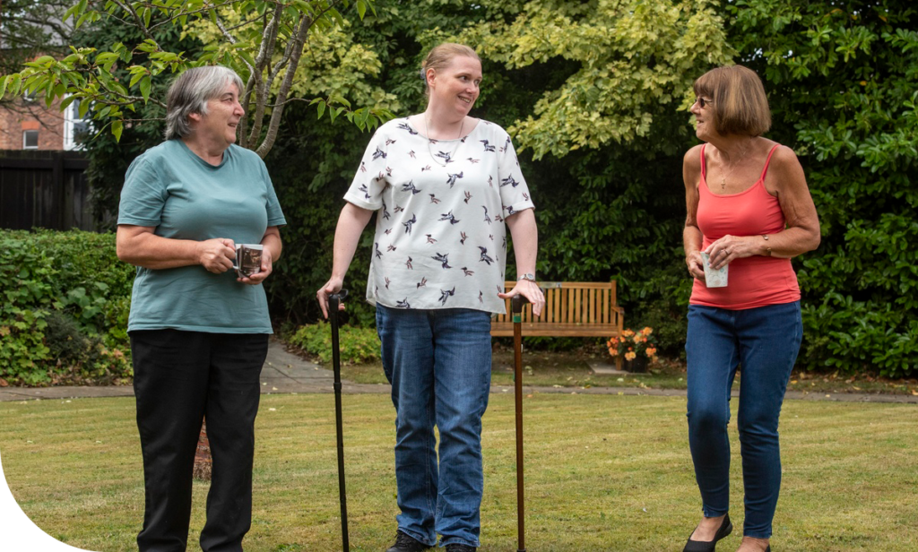 A Retirement Living Co-ordinator and customers walking together in Hob House Court based on the Wirral.