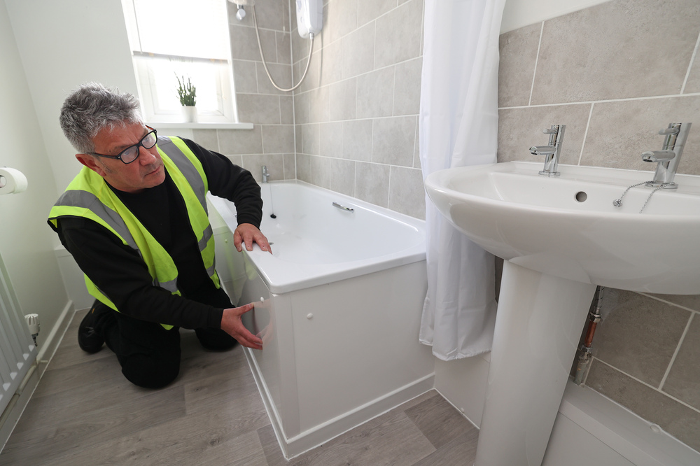 An Operative checks the bathroom in a home.