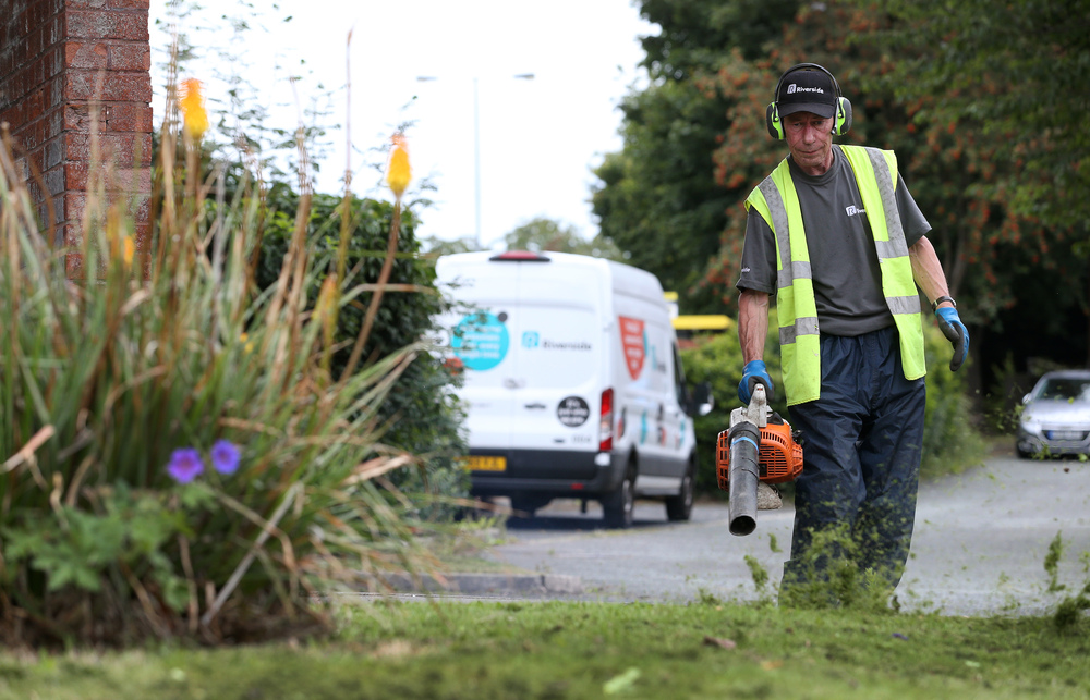 A member of the Maintenance team leaf blowing.