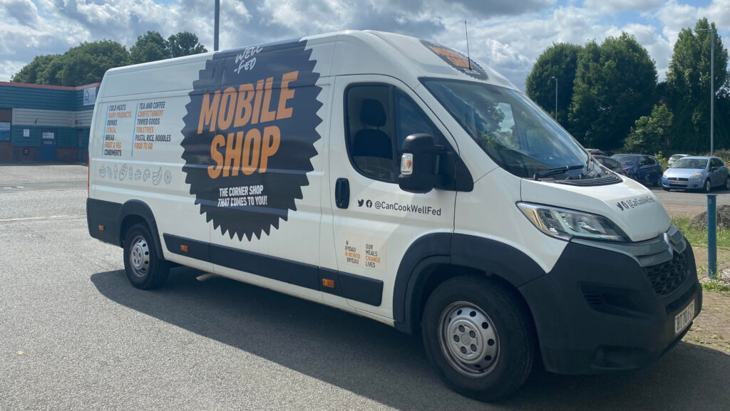 A white van with the words 'mobile shop' printed on the side of it.